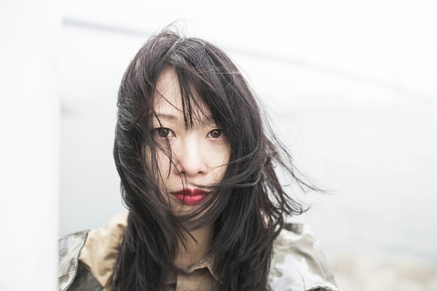 Nahaufnahme eines Portraits einer Frau mit im Wind wehenden Haaren