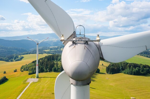 Nahaufnahme eines Propellers der Windmühle im gelben Feld mit Bergen im Hintergrund