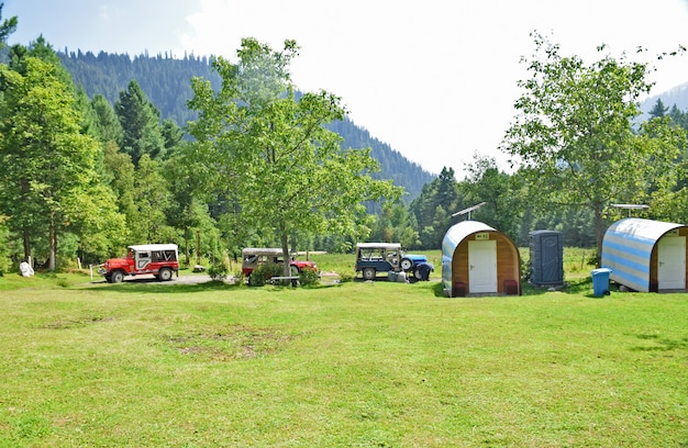 Nahaufnahme eines Resortkomplexes in einem bergigen Waldgebiet mit blauem Himmel