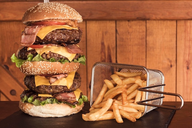 Nahaufnahme eines riesigen Dreifachstapels Hamburger und Pommes