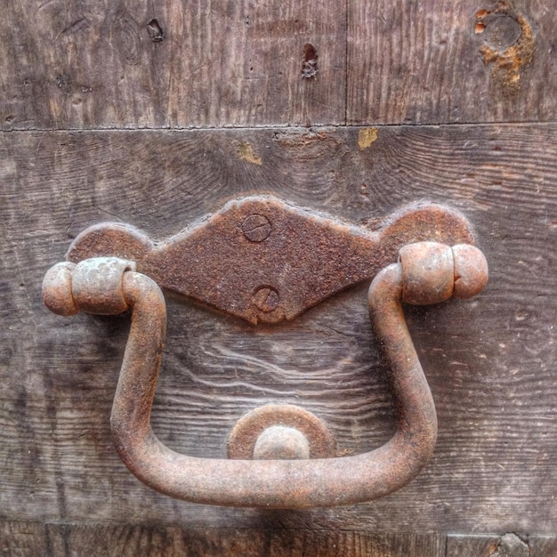 Foto nahaufnahme eines rostigen metallischen griffes auf holz