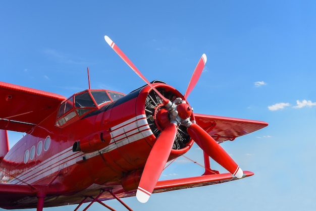 Nahaufnahme eines roten Doppeldeckers vor dem Hintergrund des Himmels Flugzeug mit Motor und Propeller