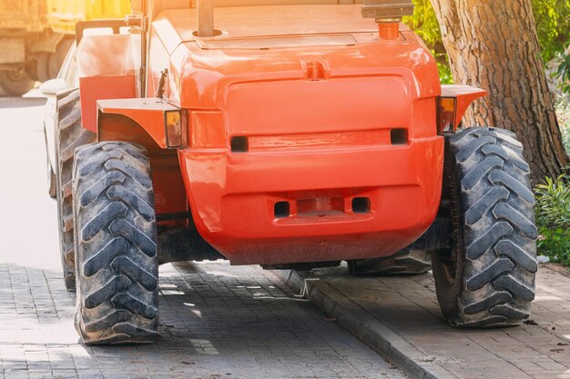 Nahaufnahme eines roten, leistungsstarken Traktors. Schwere Maschinen für industrielle und landwirtschaftliche Aufgaben