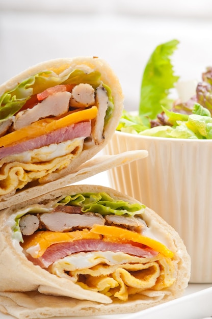 Nahaufnahme eines Sandwiches mit Gemüse, das auf einem Teller serviert wird