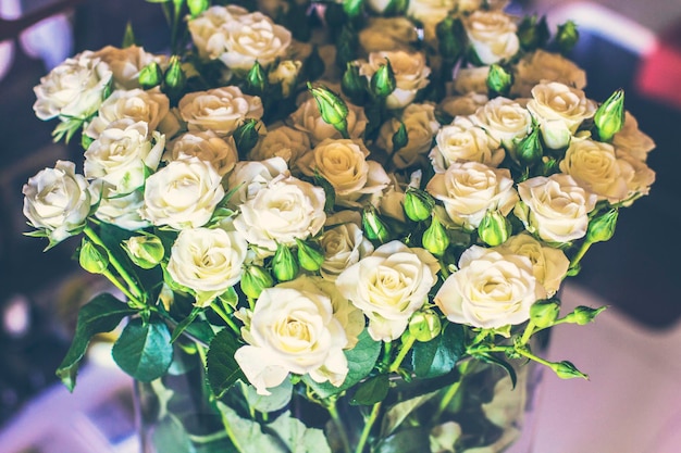 Nahaufnahme eines schönen Blumenstraußes aus weißen Rosen in Vintage-Tönung