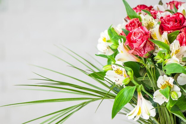 Nahaufnahme eines schönen Blumenstraußes mit Rosen und weißen Alstroemeria lokalisiert auf einem weißen Hintergrund