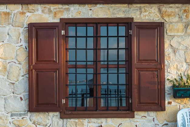 Nahaufnahme eines schönen schwarzen geschmiedeten Zauns an einem Fenster in einem alten Haus