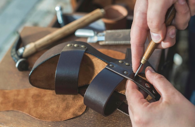Nahaufnahme eines Schuhmachers, der eine Sandale in einer Werkstatt herstellt
