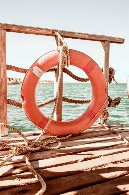 Foto nahaufnahme eines seils, das an einen holzpfahl am strand gegen den himmel gebunden ist