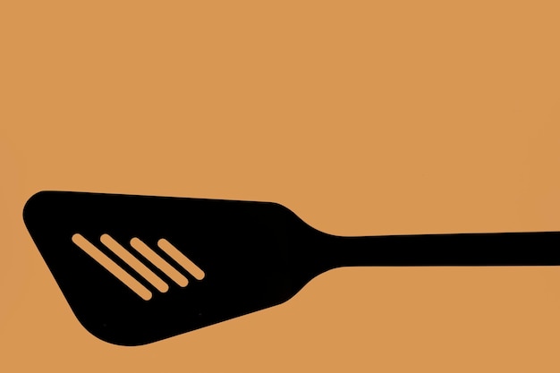 Foto nahaufnahme eines silhouette-küchenutensils auf orangefarbenem hintergrund