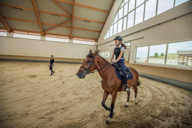 Nahaufnahme eines slowenischen Mädchens, das in einer Reitarena auf einem Pferd reitet