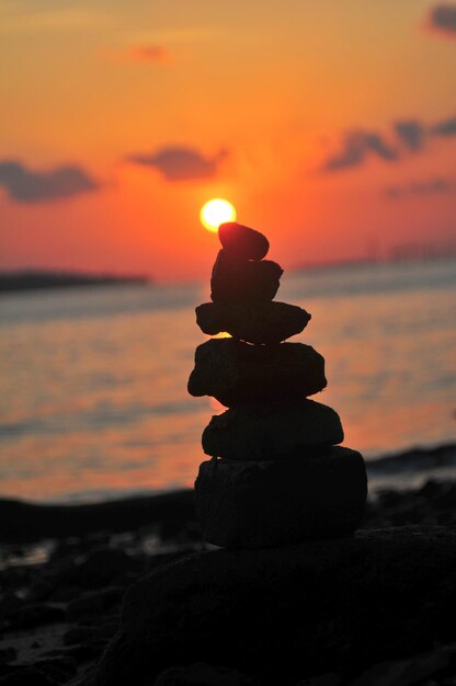 Foto nahaufnahme eines steinhaufens am strand bei sonnenuntergang