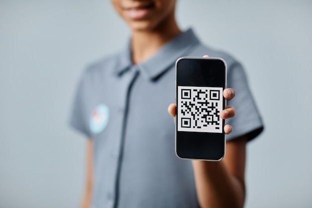 Nahaufnahme eines süßen afroamerikanischen Mädchens, das QR-Code zeigt, nachdem es einen Kopierraum geimpft hat