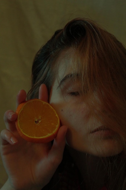 Nahaufnahme eines Teenager-Mädchens, das eine Orange hält