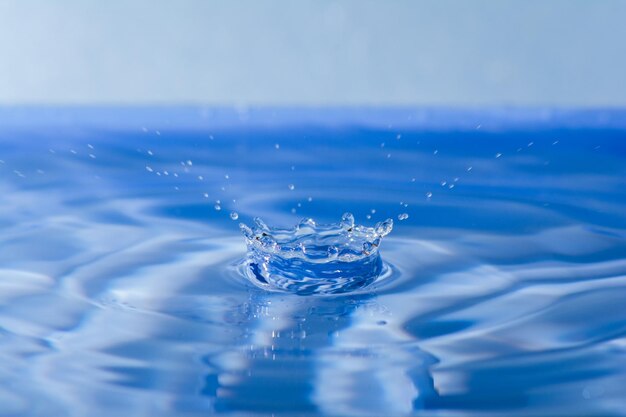 Nahaufnahme eines Tropfens, der auf krümmendes Wasser fällt