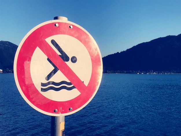 Foto nahaufnahme eines warnschildes am see gegen den himmel