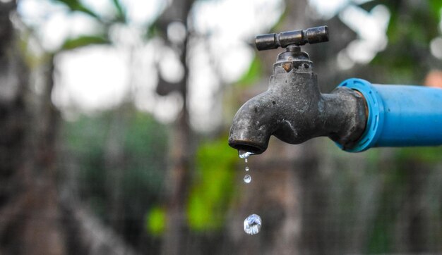 Foto nahaufnahme eines wassertrops, der aus dem wasserhahn fällt