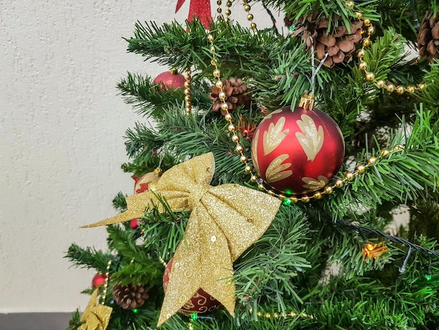 Nahaufnahme eines Weihnachtsbaumes, der mit Bögen, funkelnden Glaskugeln und Weihnachtsbaumspielzeug geschmückt ist