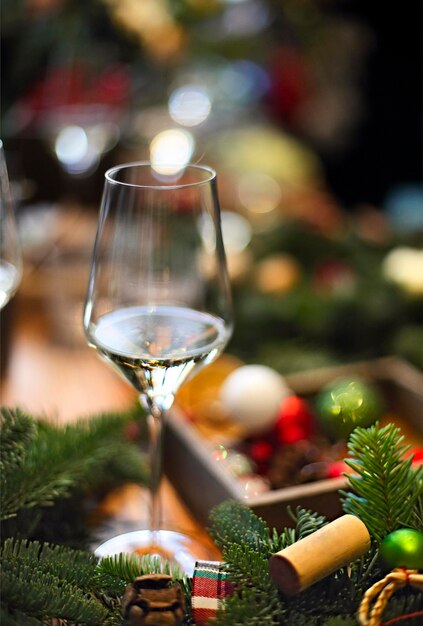 Foto nahaufnahme eines weinglases auf dem tisch gegen den weihnachtsbaum