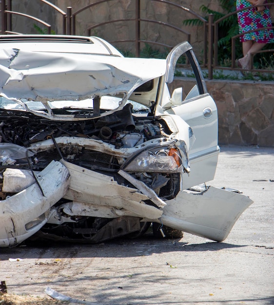 Nahaufnahme eines weißen Autos, das bei einem Autounfall zerstört wurde Beschädigte vordere Stoßfänger-Motorscheinwerfer