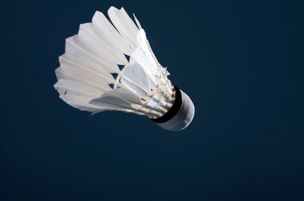 Foto nahaufnahme eines weißen shuttlecocks vor schwarzem hintergrund