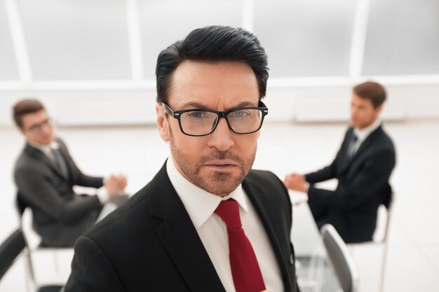 Nahaufnahme ernster Geschäftsmann im Hintergrund der Konferenzraumgeschäftsleute