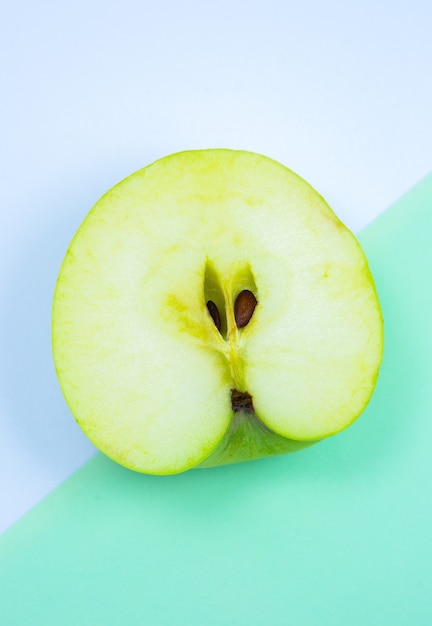 Nahaufnahme Foto von Green Apple Fruit auf dem weißen und grünen Hintergrund. Minimalismus, originelles und kreatives Bild.