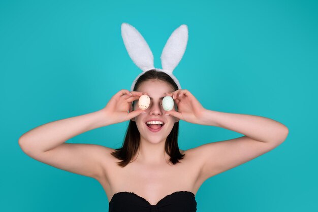 Nahaufnahme Foto von hübschen Mädchen tragen flauschige Osterhasenohren halten Ostereier isoliert Studio Backgro