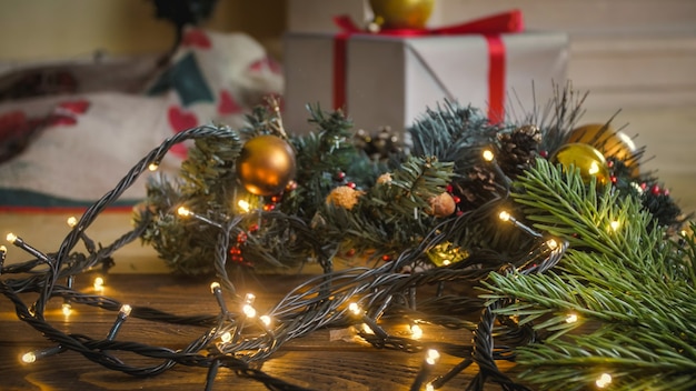 Nahaufnahme getöntes Bild von leuchtendem Weihnachtslicht auf Holzboden im Wohnzimmer