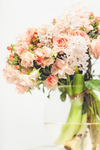 Nahaufnahme getöntes Foto von kleinen rosa Blumen in Glasvase