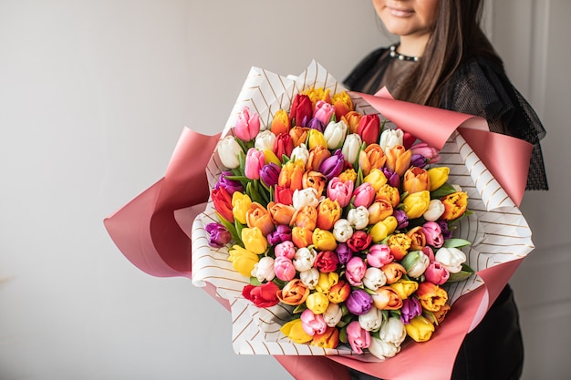 Foto nahaufnahme groß schöner strauß gemischter tulpen. blumenhintergrund und hintergrundbild. blumengeschäftskonzept. schönes frisch geschnittenes bouquet. blumenlieferung