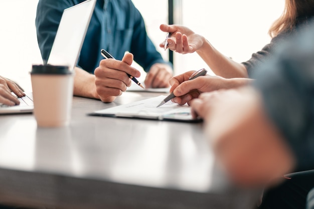 Nahaufnahme. Gruppe von Mitarbeitern, die an einem Bürotisch sitzen