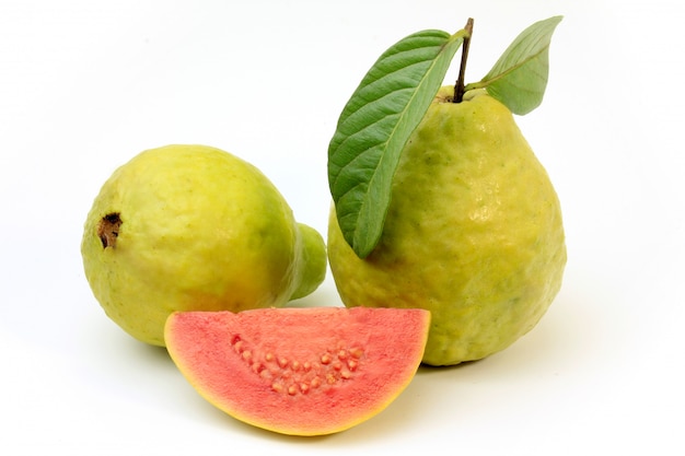 Nahaufnahme Guajava-Frucht, rosa, frisch, organisch, mit den Blättern, ganz und geschnitten, lokalisiert auf weißem Hintergrund. Vorderansicht