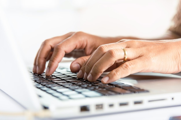 Nahaufnahme Hände der Geschäftsfrau über Laptop-Tastatur während der Arbeit am Schreibtisch