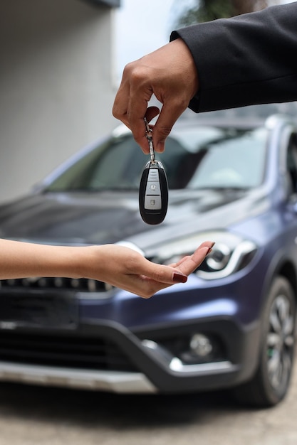 Nahaufnahme Hände des Kunden kauft ein Auto und erhält Schlüssel vom Verkäufer.