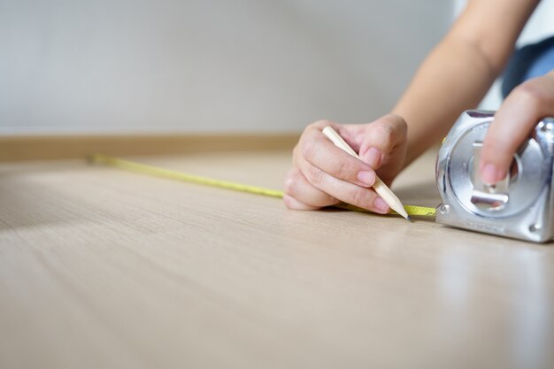 Nahaufnahme Hände Frau Ingenieur mit gelbem Zimmermannsband