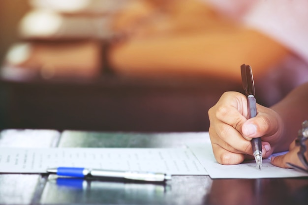 Nahaufnahme Hände Schüler, die Prüfungen ablegen, Prüfungsprüfungen im Klassenzimmer, um im letzten aufzusteigen