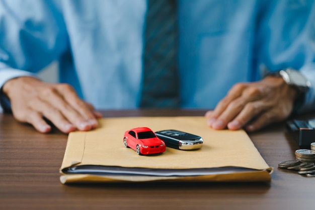 Nahaufnahme Hand des Autoverkäufers Liefern Sie das Auto und die Autoschlüssel zusammen mit den Dokumenten an Kunden, nachdem sie den Kaufvertrag rechtsgültig unterzeichnet haben, Erfolgreicher Abschluss des Autoverkaufs,