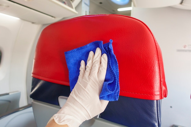 Nahaufnahme Hand trägt Handschuhe Reinigung Flugzeuge für Covid-19-Prävention Pandemie