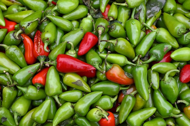 Nahaufnahme Haufen vieler frischer grüner und roter scharfer Jalapeno-Chilischoten im Einzelhandel auf dem Bauernmarkt, erhöhte Draufsicht, direkt darüber