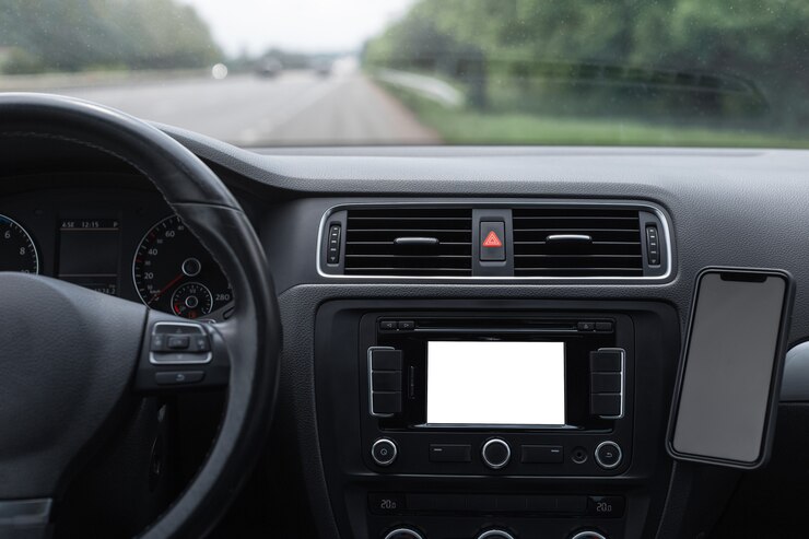 Nahaufnahme innerhalb des Autos des Armaturenbretts mit leerem Modell auf dem Bildschirm und Smartphone