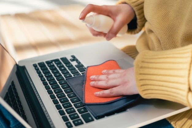 Nahaufnahme. junge Frau, die ihren Laptop von Virusbakterien behandelt. Foto mit einer Kopie des Raumes