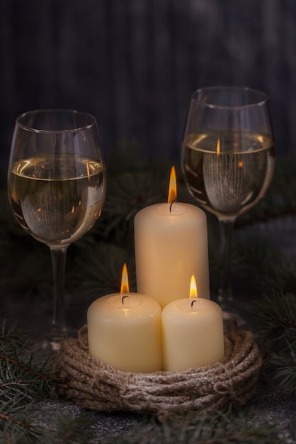 Nahaufnahme Kerzen und Gläser Wein mit Weihnachtsbaum