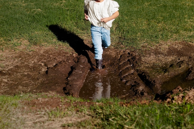 Foto nahaufnahme kind, das im schlamm läuft