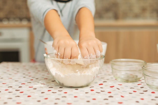 Nahaufnahme Kind Hände in einer Glasschüssel mit Mehl auf der Küche t