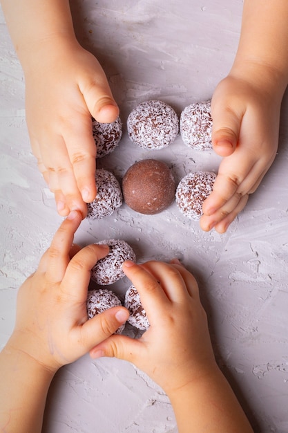 Nahaufnahme Kinder, die Trüffel mit Nüssen und Datteln teilen