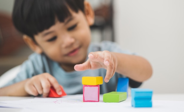 Nahaufnahme Kinderhand Üben Sie die Fähigkeiten des Spielens mit Holzspielzeug auf dem Tisch im Wohnzimmer Asiatische kleine Jungenerziehung von zu Hause aus Entwicklung des Lernens von Kindern vor dem Eintritt in den Kindergarten