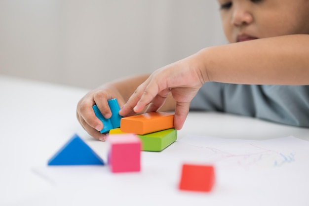 Nahaufnahme Kinderhand Üben Sie die Fähigkeiten des Spielens mit Holzspielzeug auf dem Tisch im Wohnzimmer Asiatische kleine Jungenerziehung von zu Hause aus Entwicklung des Lernens von Kindern vor dem Eintritt in den Kindergarten