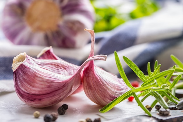 Nahaufnahme Knoblauchzehen und Zwiebeln mit Rosmarinsalz und Pfeffer.