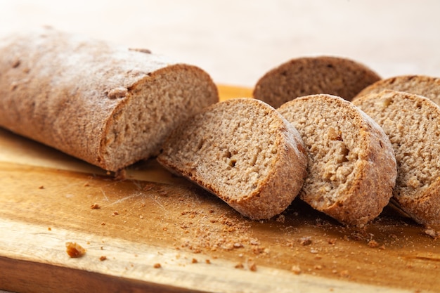 Nahaufnahme knuspriges gehacktes braunes Roggenbrot, Scheiben auf Holzschneidebrett. Horizontal